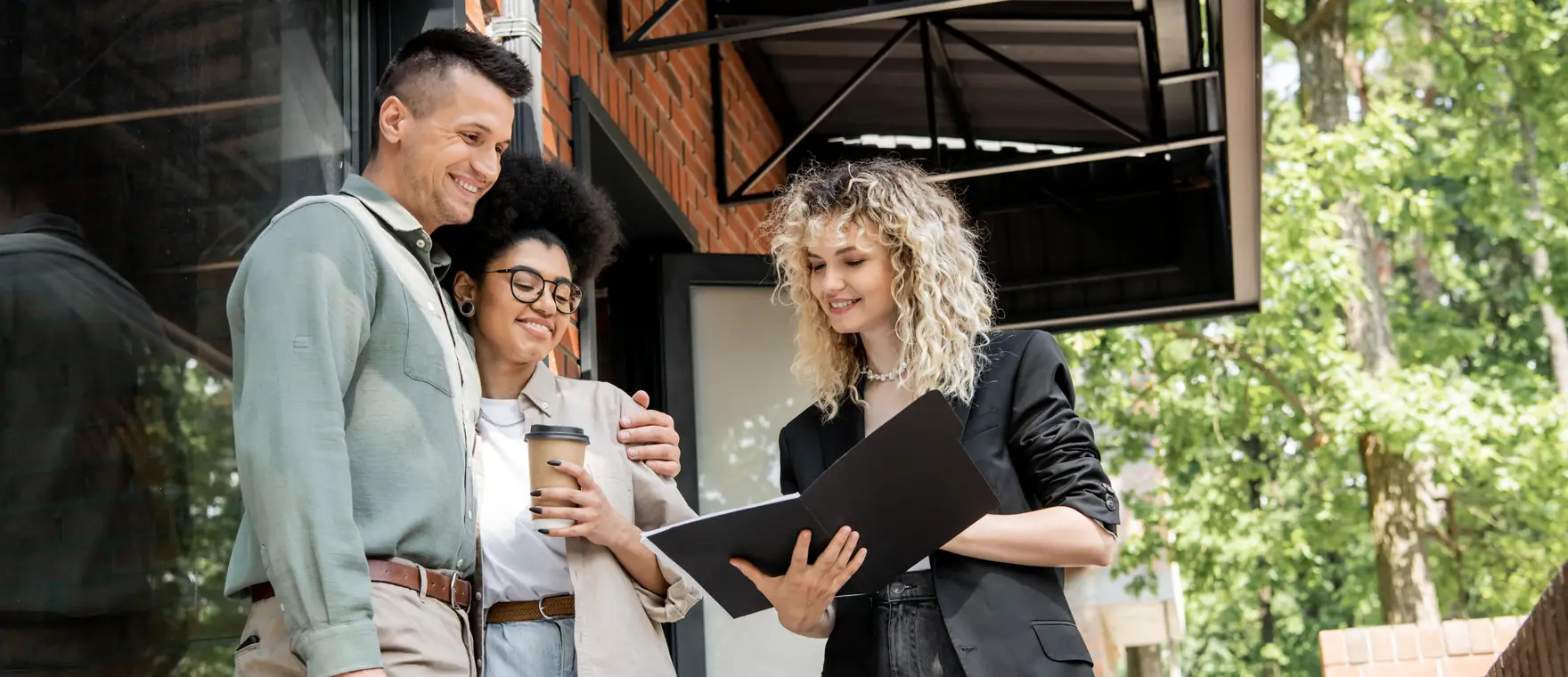 A property manager going over paperwork with residents outside a building
