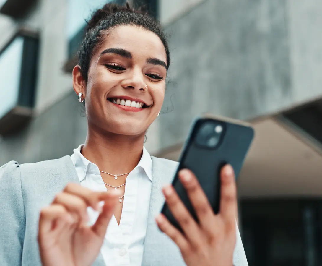 A professional checking her phone outside an office