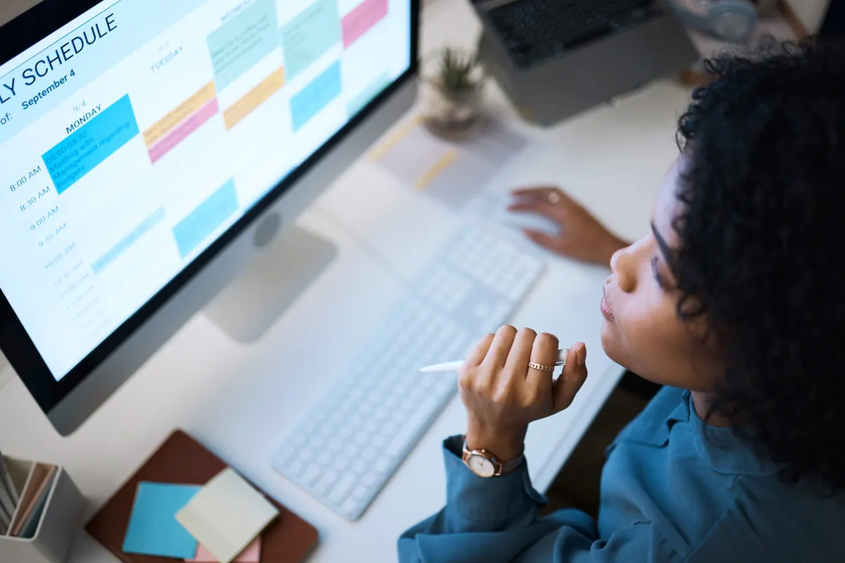 A manager reviewing the week's schedule and workflows on screen